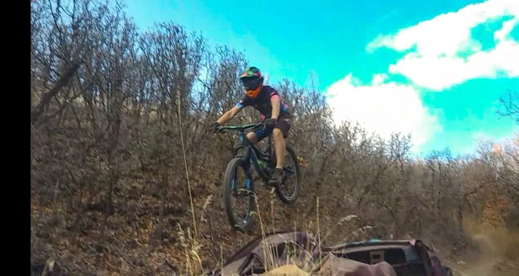 Jim-E jumping a bike over a car
