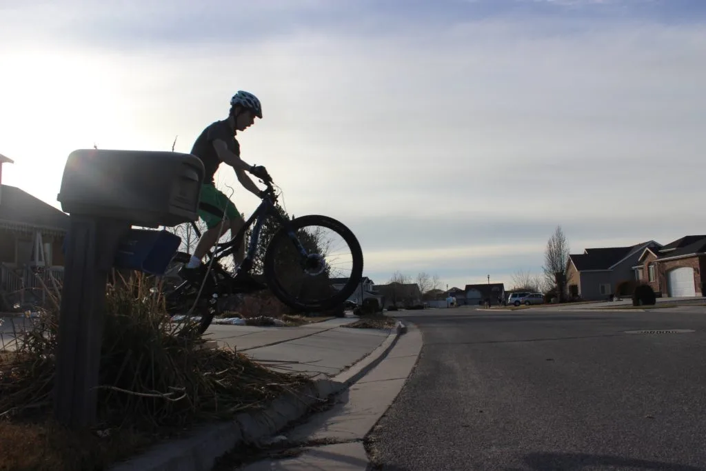 Jim-E jumping a bike off of a curb