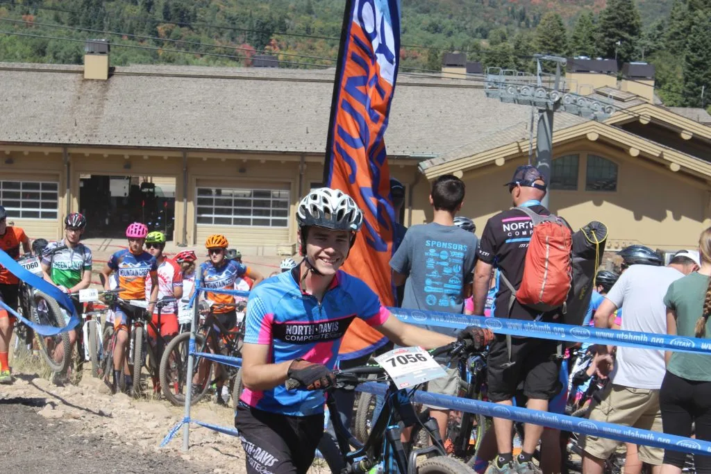 Jim-E walking a bike to the start of a race in snowbasin